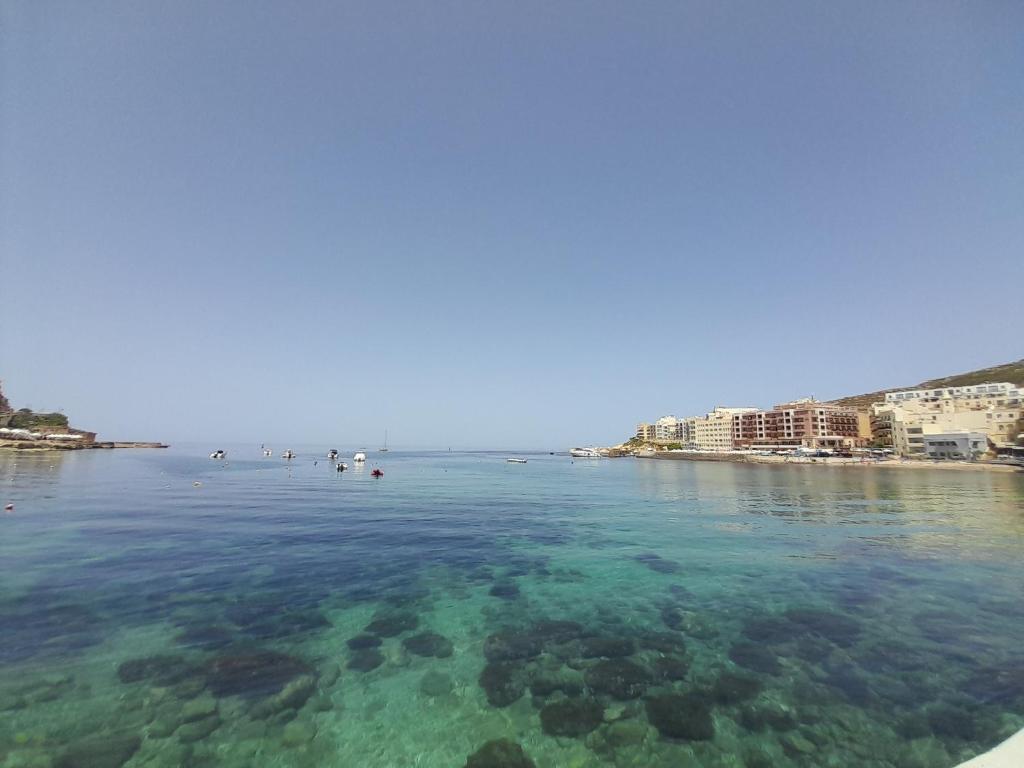 duży zbiornik wody z plażą i budynkami w obiekcie Gozo Marsalforn w mieście Marsalforn