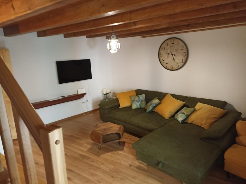 a living room with a couch and a clock on the wall at Casa Mali in Cres