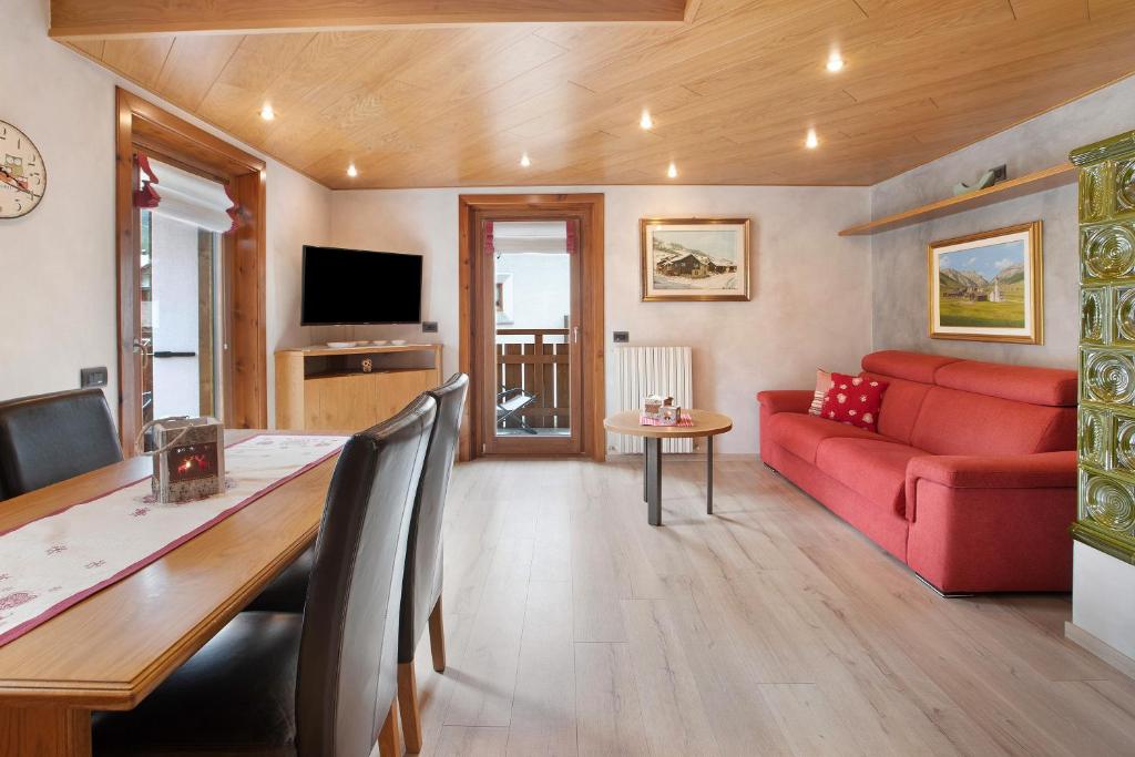 a living room with a red couch and a table at Casa Marmut in Livigno