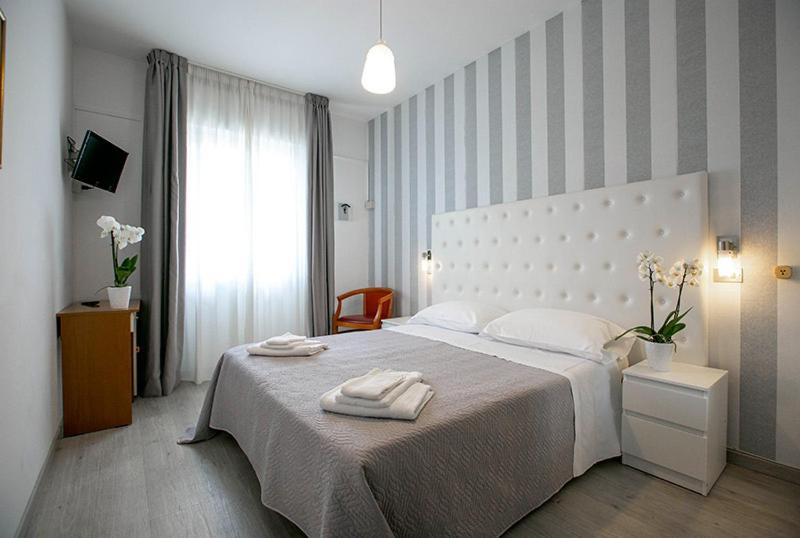 1 dormitorio con 1 cama con 2 toallas en Hotel La Perla Rimini, en Rímini