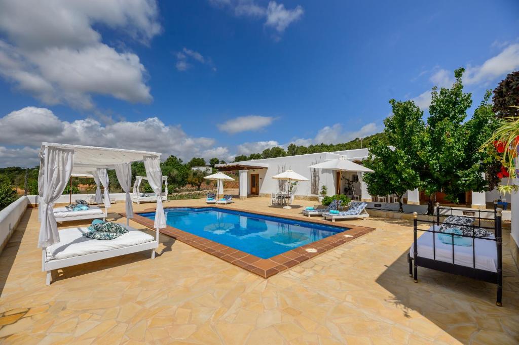 a pool with two chairs and a gazebo at Can Balafi in Cala Llonga