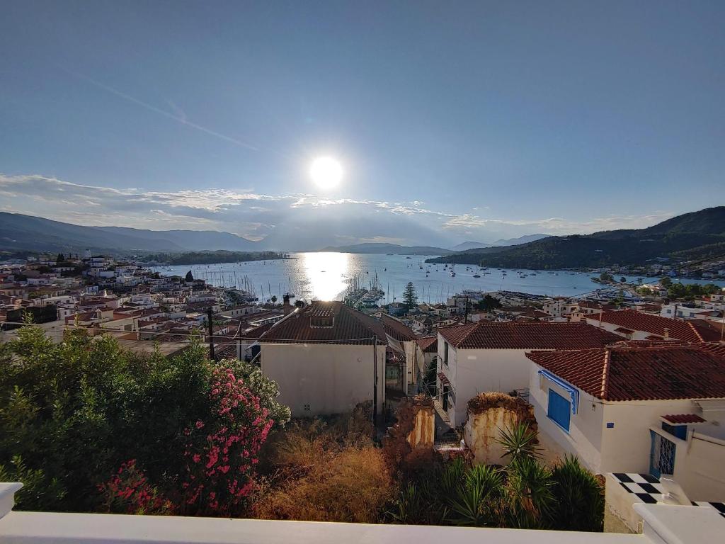 a view of a city with the sun in the sky at Summer Dream in Poros