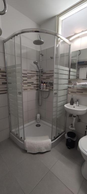 łazienka z prysznicem i umywalką w obiekcie Fürdő Apartman w mieście Makó