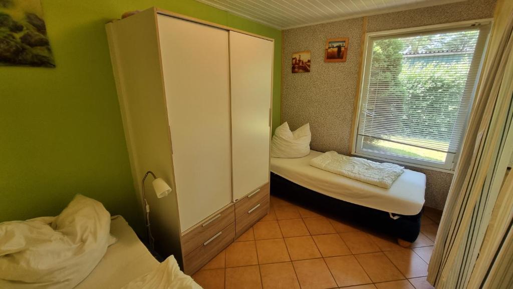 アールベックにあるBungalow (hälfte) Backbord Ahlbeck (Usedom)のベッド2台と窓が備わる小さな客室です。