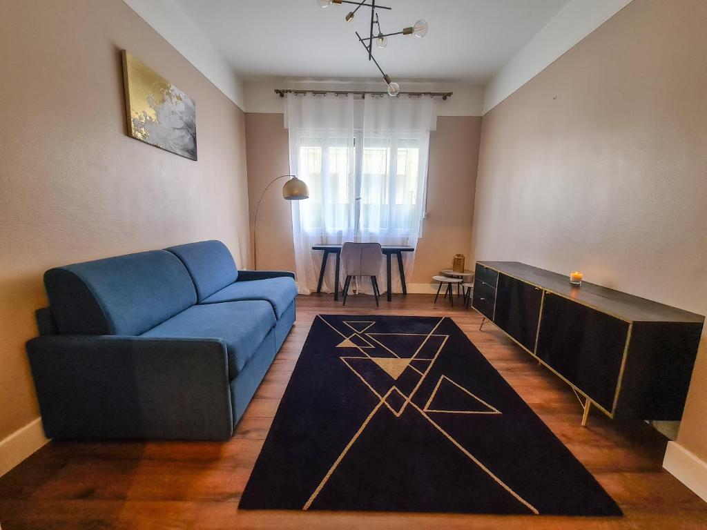 un salon avec un canapé bleu et une table dans l'établissement Appartement Nice à proximité de la plage, à Nice