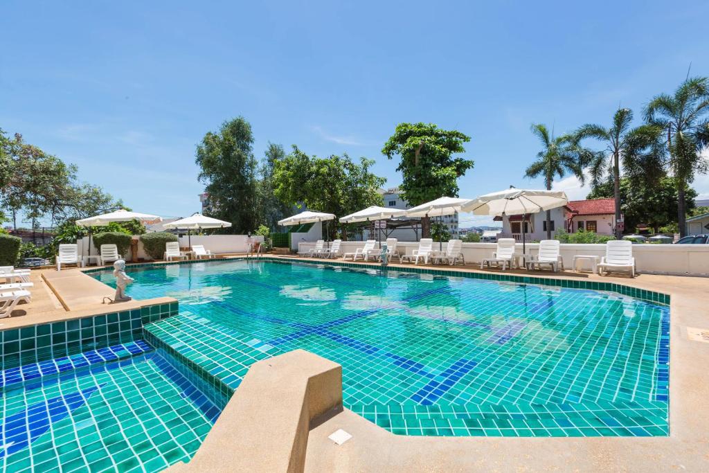 a large swimming pool with chairs and umbrellas at Hotel Zing in Pattaya South