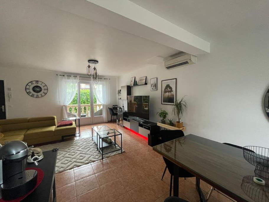 uma sala de estar com um sofá e uma mesa em Proche Paris et Disney Maison 90 M2 CLIMATISÉ bord de Marne em Gournay-sur-Marne