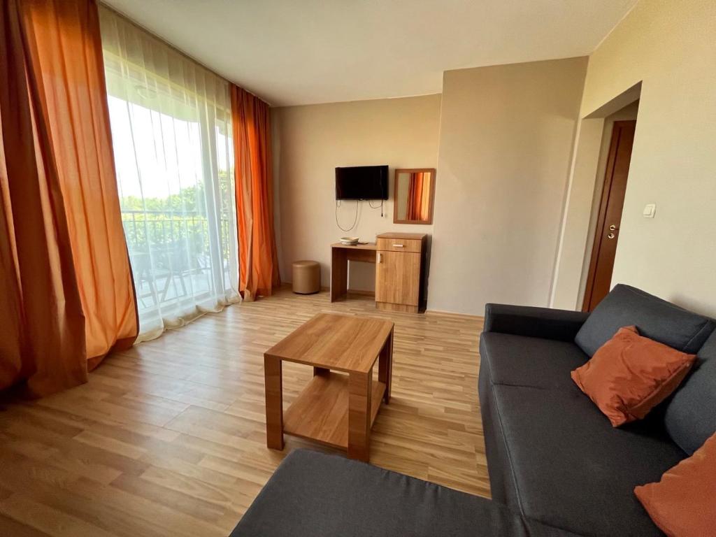 a living room with a couch and a table at Family Hotel Astra in Chernomorets