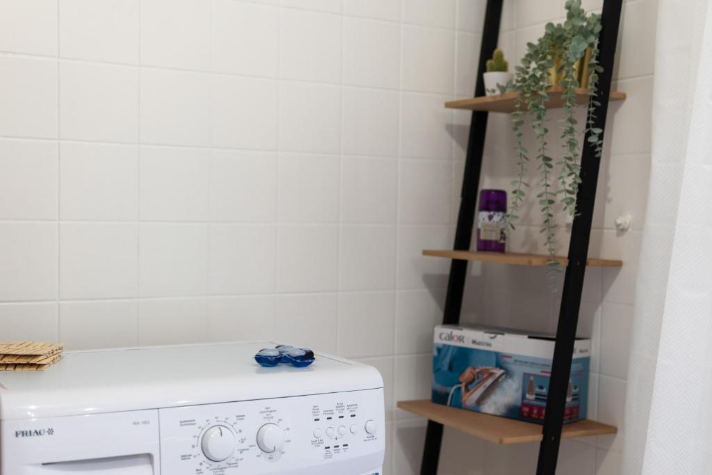 a laundry room with a washing machine and shelves at City apartment 3 BEDROOM, KITCHEN, WIFI, WORKSPACE, COFFEE, Central in Hasselt