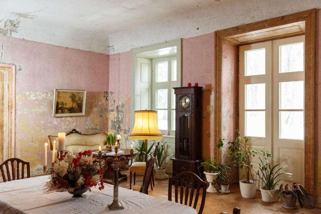 a dining room with a table and a clock on the wall at Padures muiža in Padure