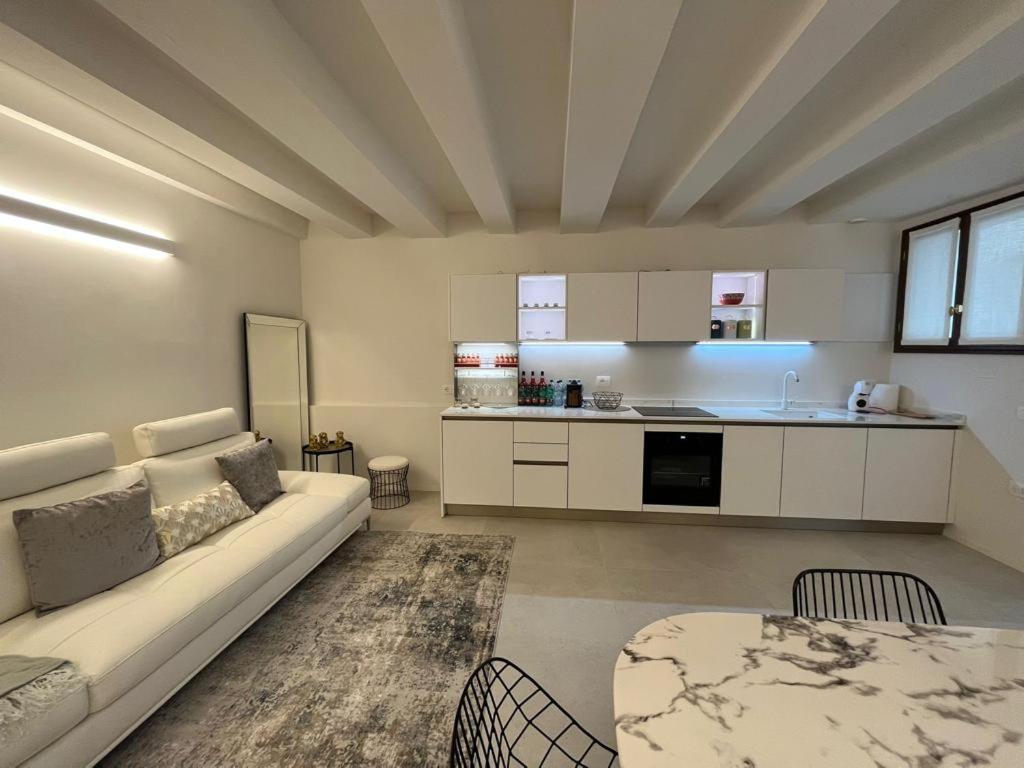 uma grande sala de estar com um sofá e uma mesa em Immobiliare Nk Palazzo Bonvicini em Veneza
