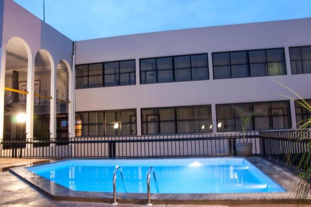 a large swimming pool in front of a building at Hotel Portal Premium in Brumado