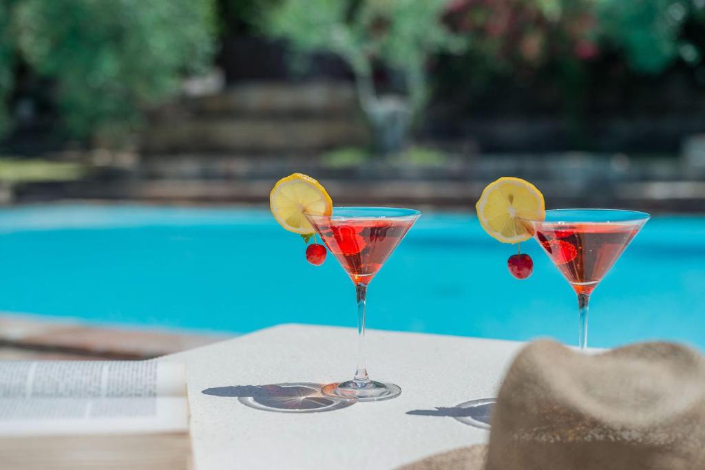 two martinis with fruit on a table next to a pool at Villa Cavalli 10 in Ripe