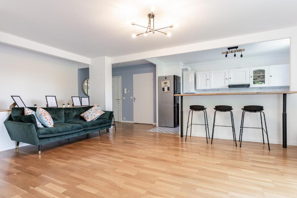 a living room with a couch and a kitchen at Design 3 bedrooms appartment, near Champs Elysees in Nanterre