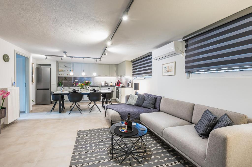 Il comprend un salon avec un canapé et une cuisine. dans l'établissement Glyfada's Cosy Apartments, à Athènes