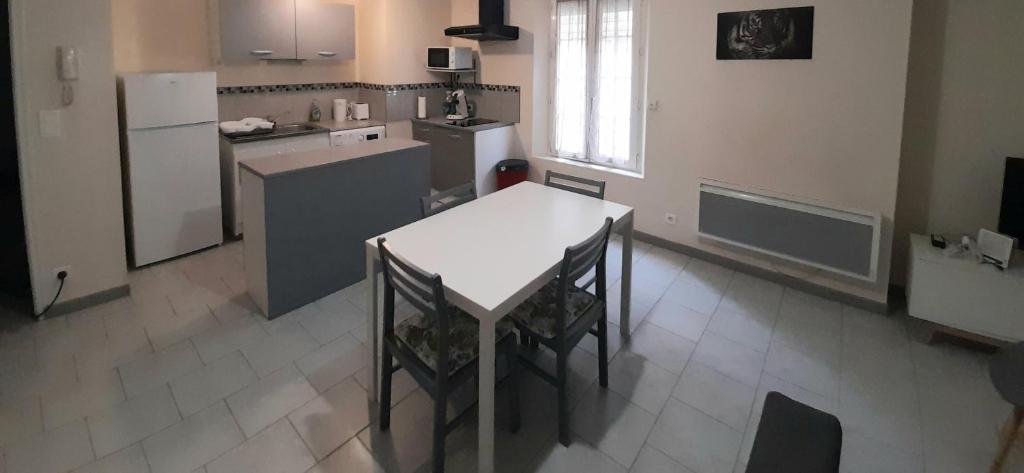uma cozinha com uma mesa branca e um frigorífico em Animalier em Joigny