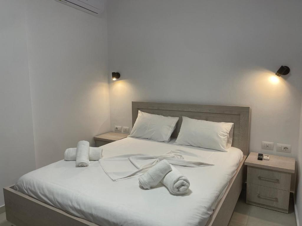 - une chambre avec un lit blanc et des serviettes dans l'établissement Villa Egli Ksamil, à Ksamil
