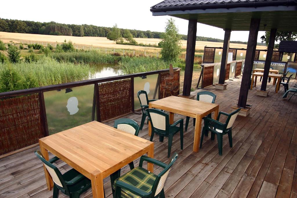 a deck with tables and chairs and a view of a river at Bumerang Jolanta Foks in Chlebów