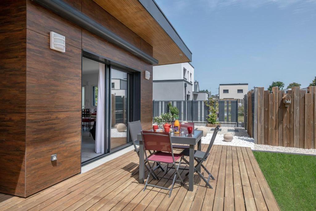 a patio with a table and chairs on a deck at Maison moderne pour 4 personnes a Saint-Gildas-de-Rhuys in Saint-Gildas-de-Rhuys
