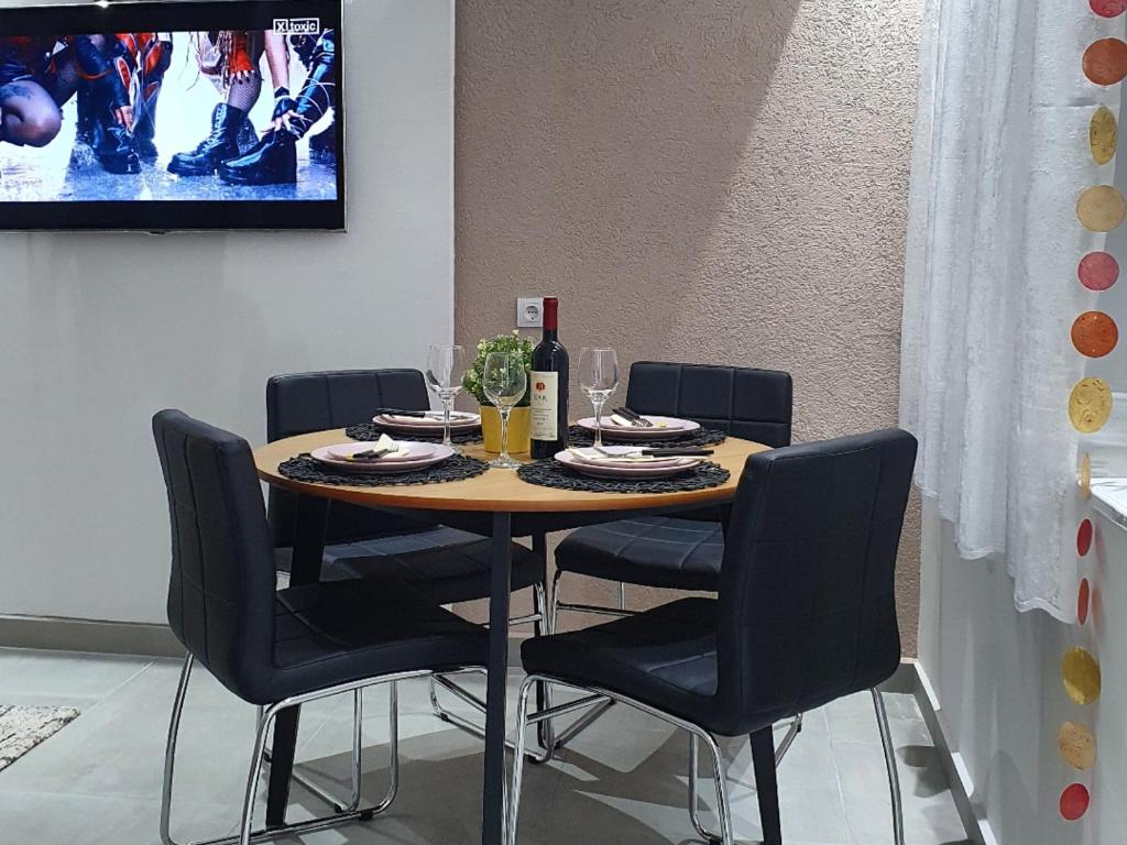 een eettafel met stoelen en een tv bij Afrodita apartment in Vrdnik