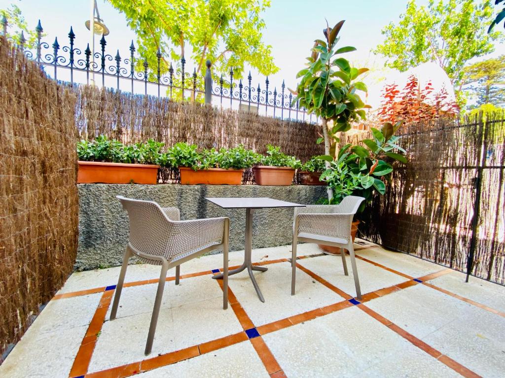 a patio with a table and two chairs and a fence at Apartamentos Turísticos Santo Rostro in Chipiona