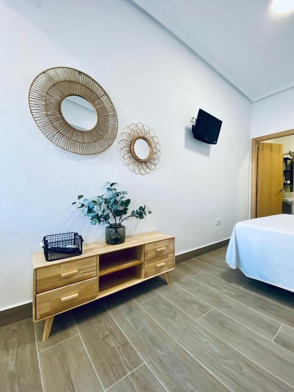a bedroom with a bed and a dresser and a mirror at Apartamentos Turísticos Santo Rostro in Chipiona