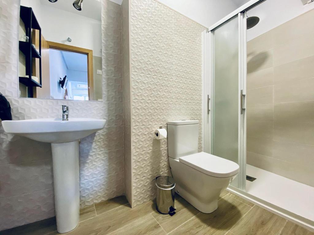 a bathroom with a toilet and a sink and a shower at Apartamentos Turísticos Santo Rostro in Chipiona