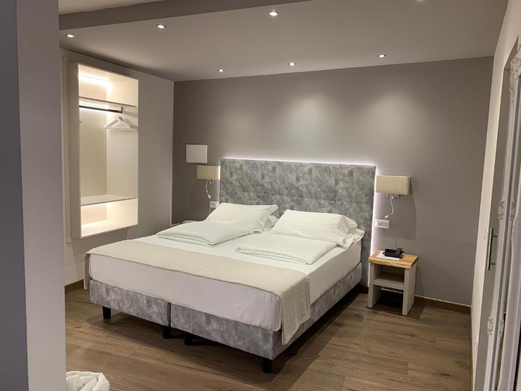 a hotel room with a white bed and white walls at Albergo Ristorante Montebaldo in Limone sul Garda