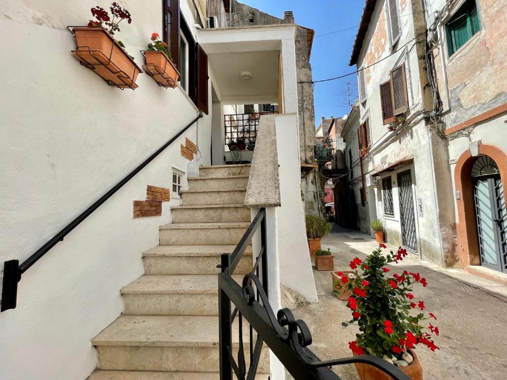 una scala che porta a un edificio con fiori rossi di Casa Vacanze nel borgo di San Felice Circeo a San Felice Circeo