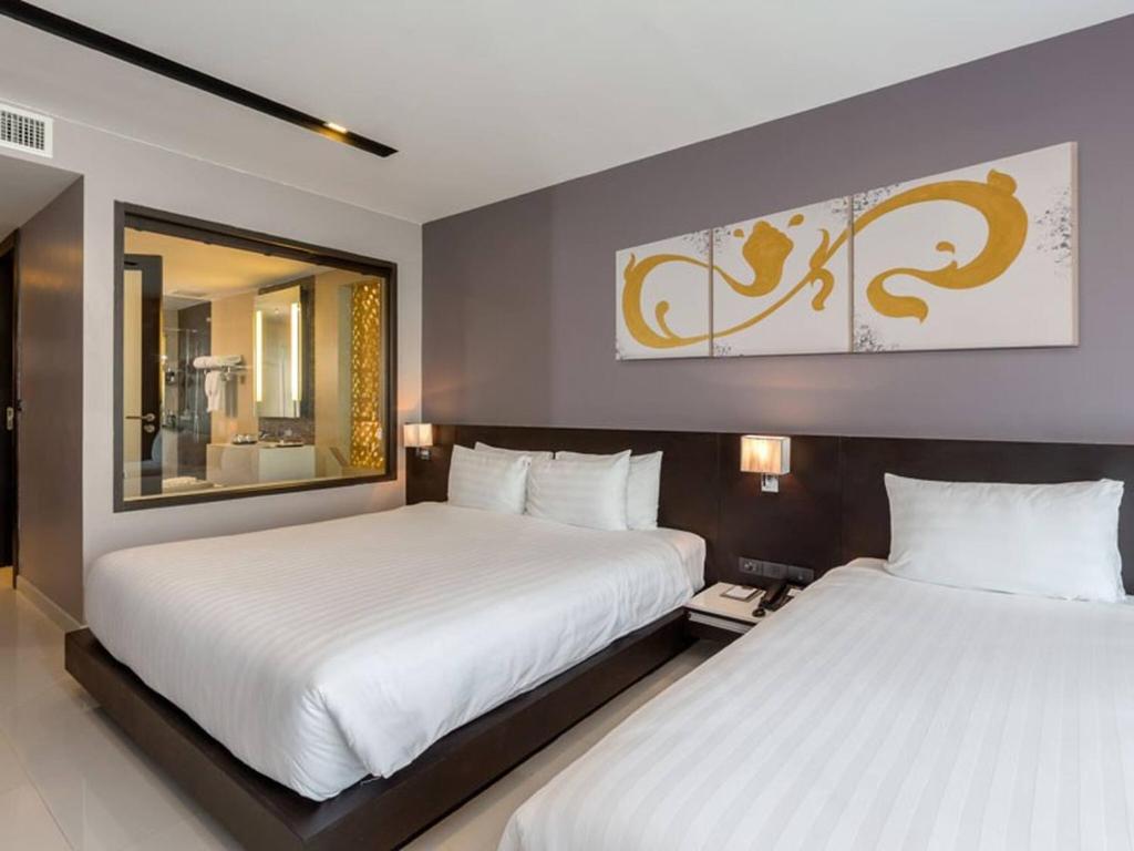 Patong Beachfront Studio 2 Mins Walk 2 Patong Beach في شاطيء باتونغ: غرفة نوم بسريرين ومرآة