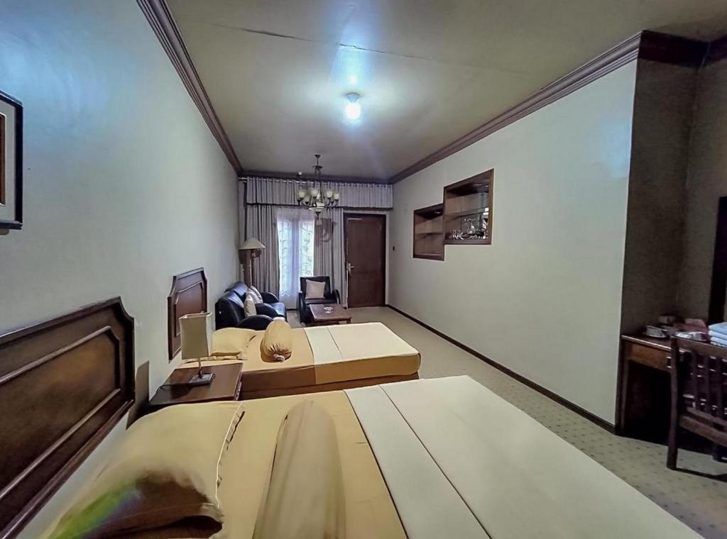 a room with a bed and a living room at Hotel Indiana Syariah Mitra RedDoorz in Tanjung