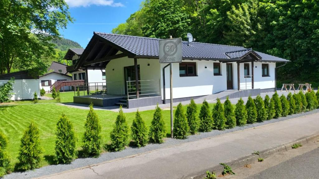a house with a row of trees in front of it at Haus DeMa in Walkenried