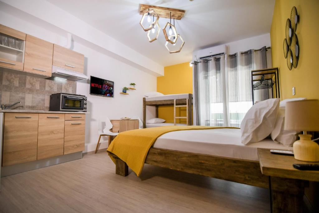 1 dormitorio con 1 cama grande con manta amarilla en Gio Apartments, en Preveza