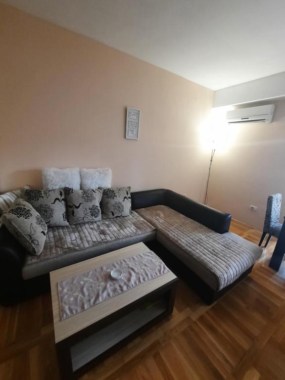 a living room with a couch and a table at Stan na dan i duže in Podgorica
