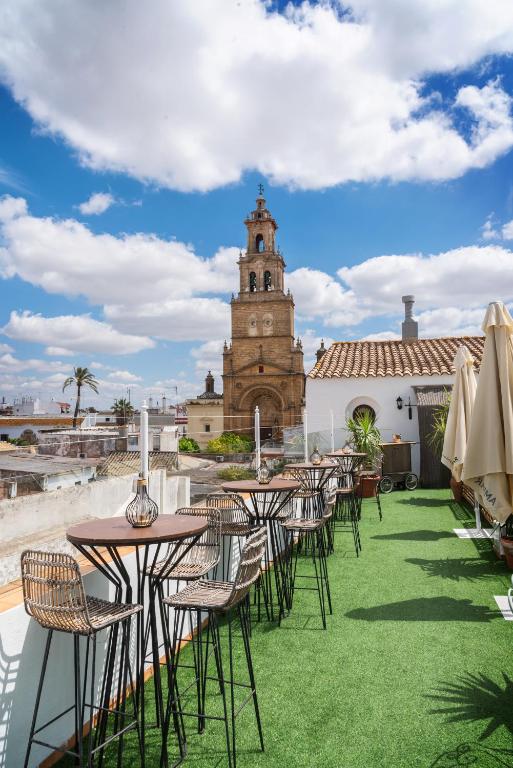 a group of tables and chairs in front of a building at Palacio San Fernando in Utrera