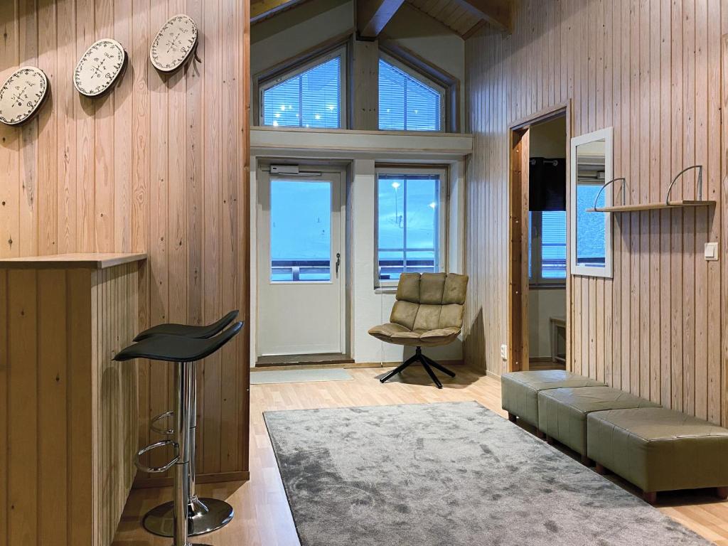 a living room with a couch and a chair and windows at Levin Alppitalot Alpine Chalets Deluxe in Levi