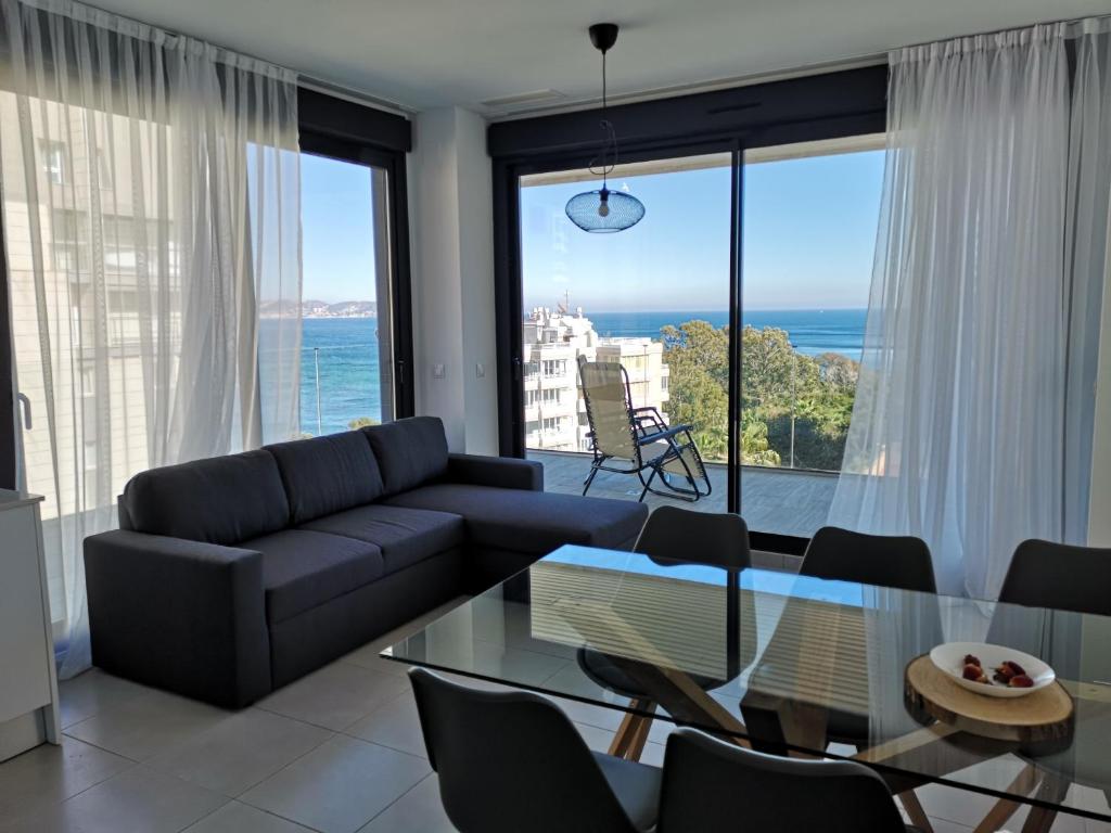 a living room with a couch and a glass table at Sea view and Ifach Calpe in Calpe