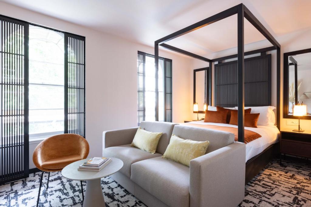 a living room with a couch and a bed at La Suite West - Hyde Park in London