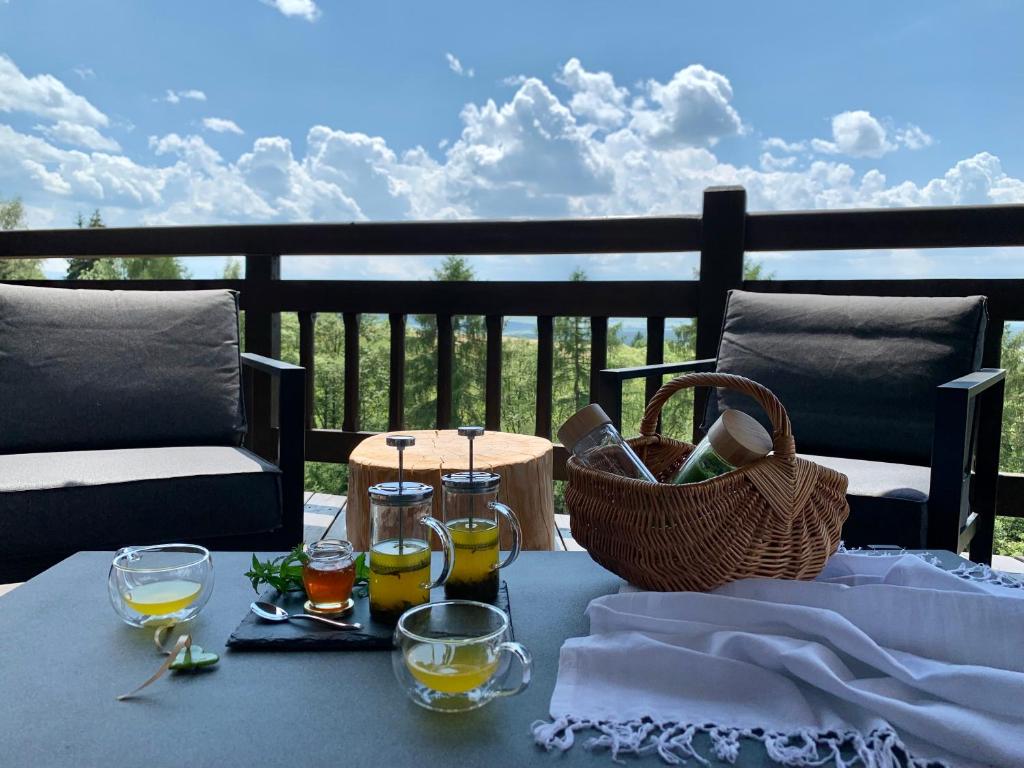 stolik z napojami i kosz na balkonie w obiekcie KOZA U WOZA WYPOCZNIJ W GÓRACH W RYTMIE SLOW drewniany dom premium z widokiem na panoramę Tatr ecoSPA strefa fitness ZIELONA FARMA warsztaty w mieście Szlembark