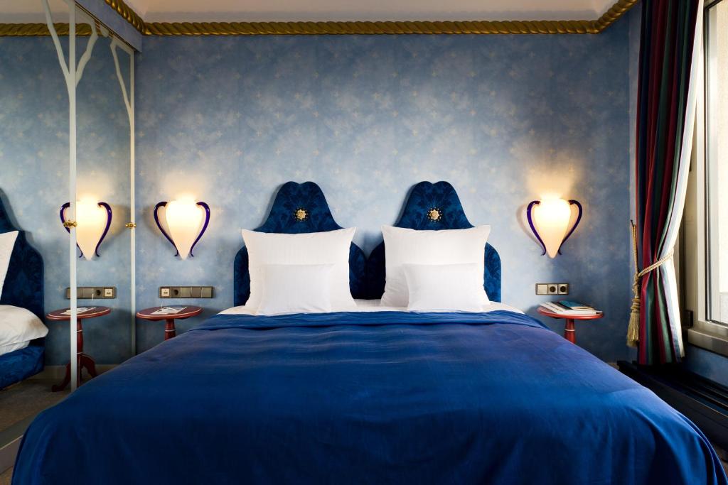 a blue bedroom with a blue bed with white pillows at Hotel Parc Belair in Luxembourg