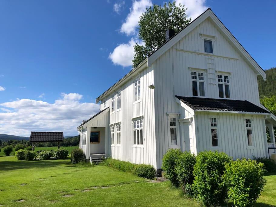 Casa blanca con un gran patio con césped en Holandsøya Gård 