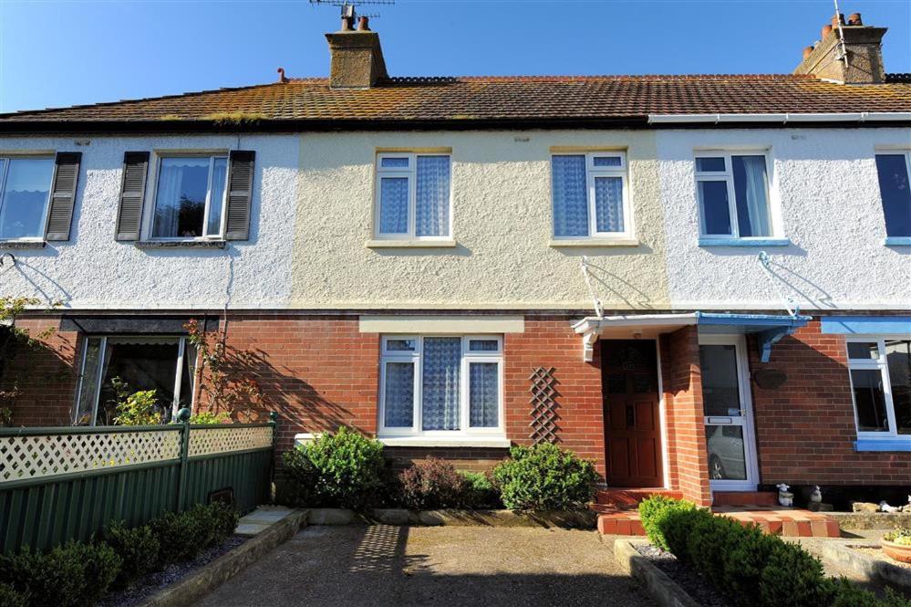 an old brick house with a red door at 23 Lym Close in Lyme Regis