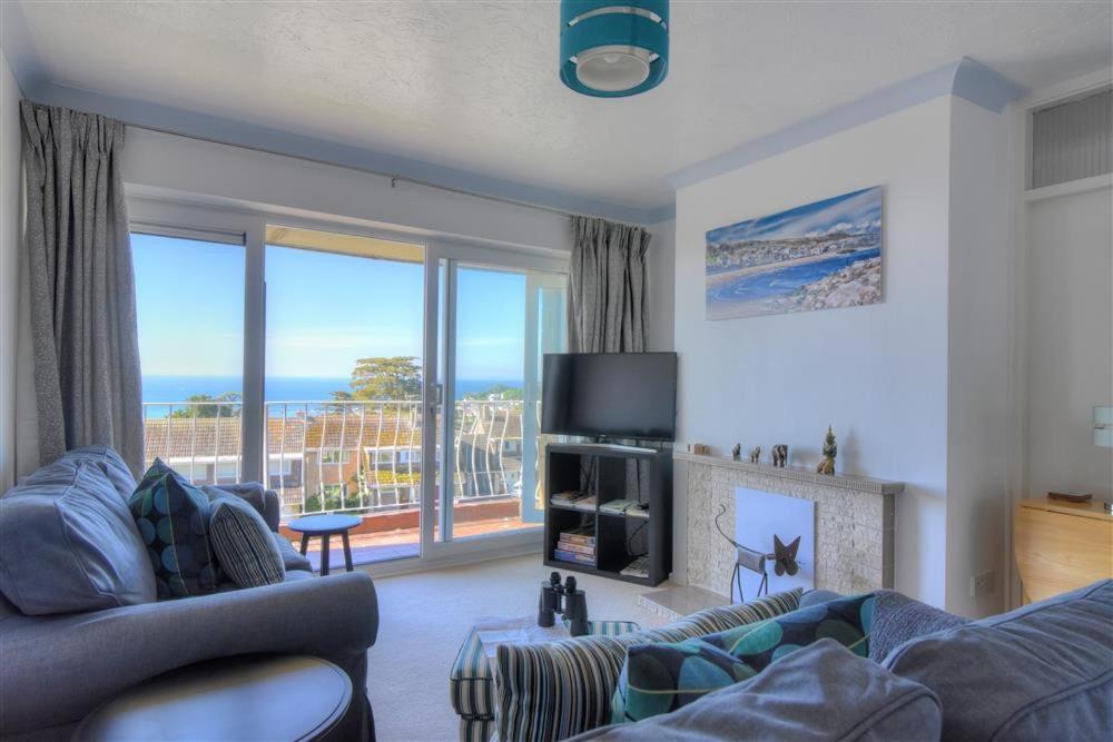 a living room with a couch and a view of the ocean at 38 Wessex Court in Lyme Regis