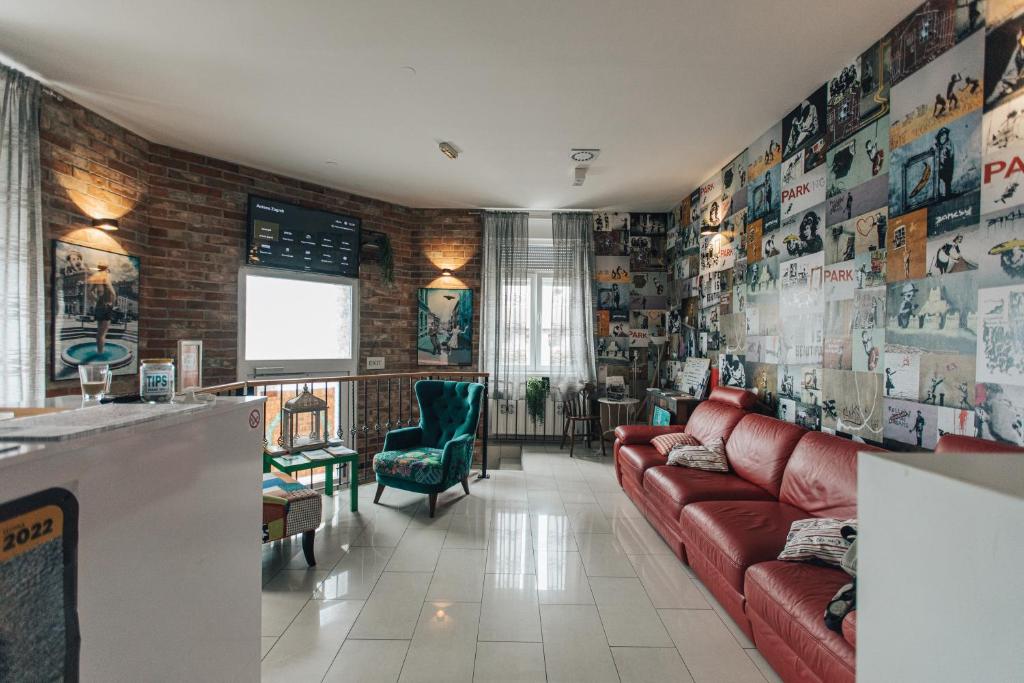 a living room with a red couch and posters on the wall at Palmers Lodge Hostel in Zagreb