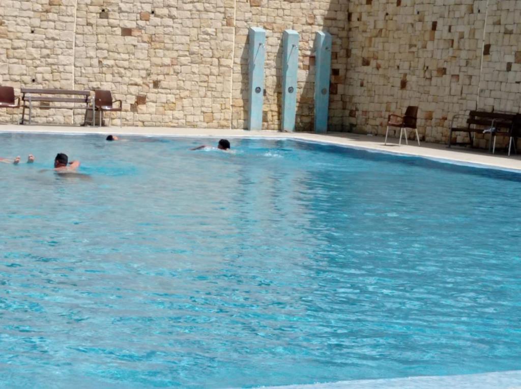 een groep mensen die zwemmen in een groot zwembad bij Résidence neuve avec piscine M’diq in M'diq