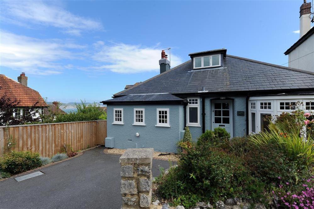 a blue house with white windows and a fence at Highpoint Lodge in Lyme Regis