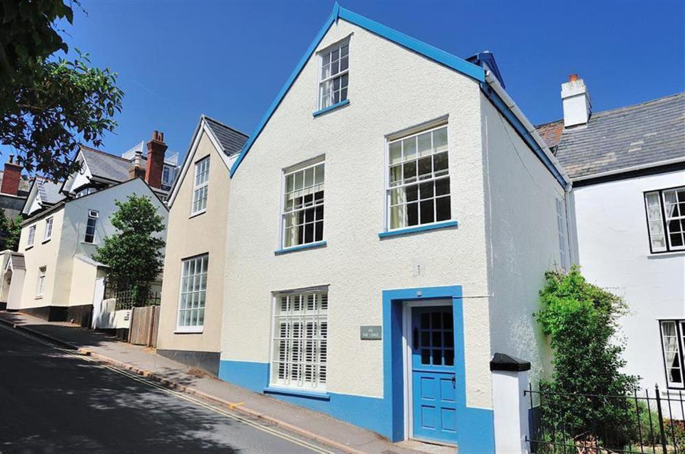 uma casa branca com uma porta azul numa rua em The Lodge em Lyme Regis