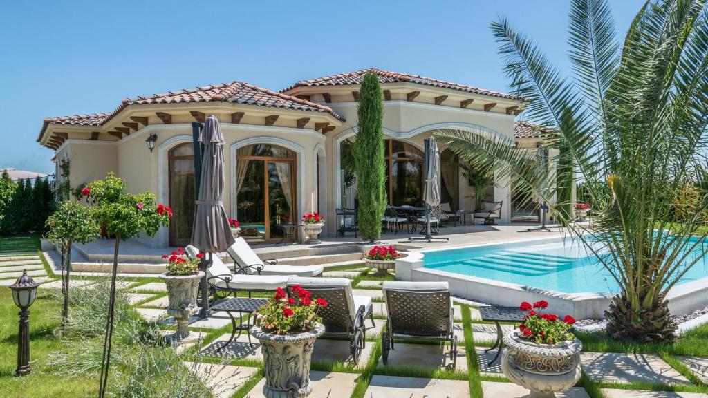 une villa avec une piscine et une maison dans l'établissement Eden Park Luxury Villas, à Sunny Beach