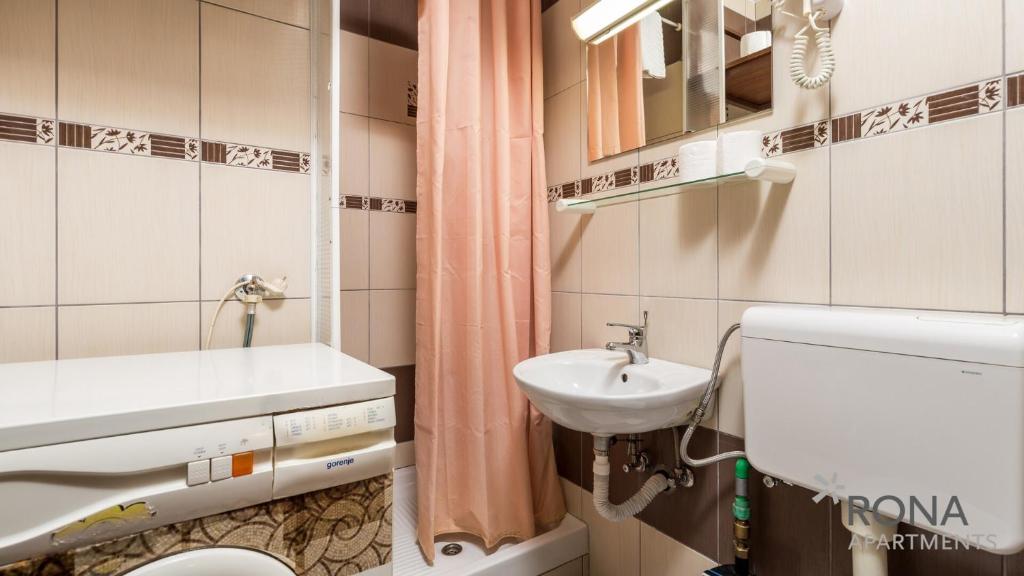 łazienka z umywalką, toaletą i lustrem w obiekcie Rona apartment Zdenka w Poreču