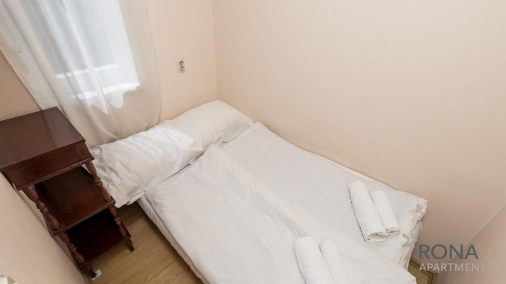 Mały pokój z łóżkiem z białą pościelą i oknem w obiekcie Rona apartment Zdenka w Poreču